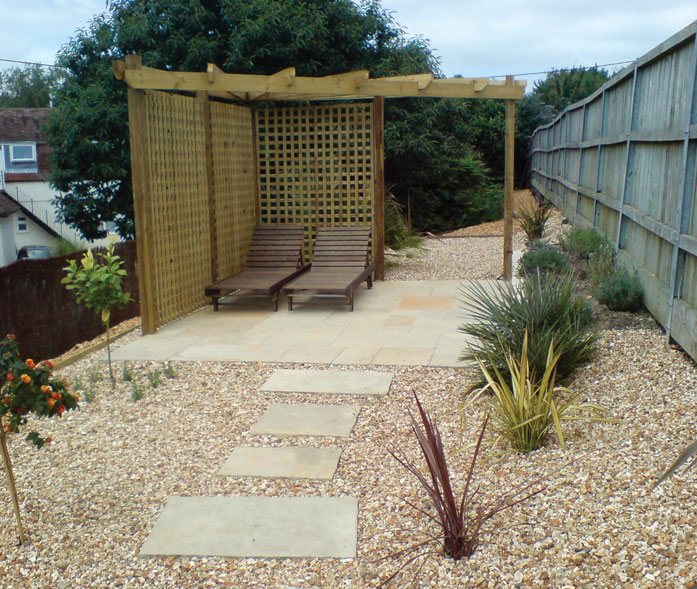 Pergola with screen trellis, 'Tuscan' limestone paving and Mediterranean planting with shingle beds.