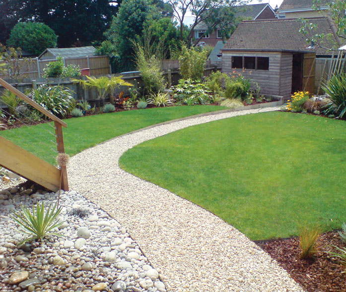 'Cotswold' stone chippings pathway through garden with cobbled beds and staircase to raised deck.