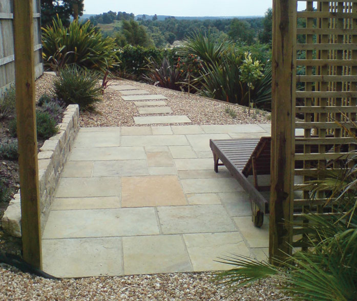 'Tuscan' limestone paving with cropped purbeck stone walling.
