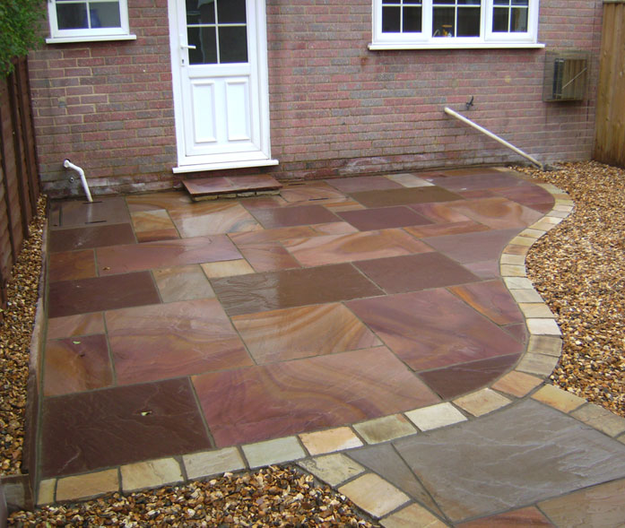 'Heather' sandstone paving with 'Golden fossil' cobbles for edging.
