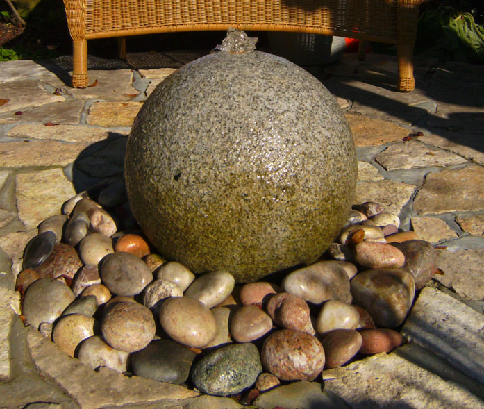 Drilled granite sphere with bubbling spout and light. Circulated through reservoir under pebbles.